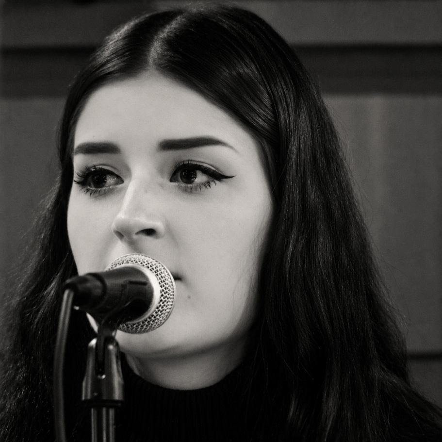 Maddy beim Singen am Mikrofon in Schwarz-Weiß