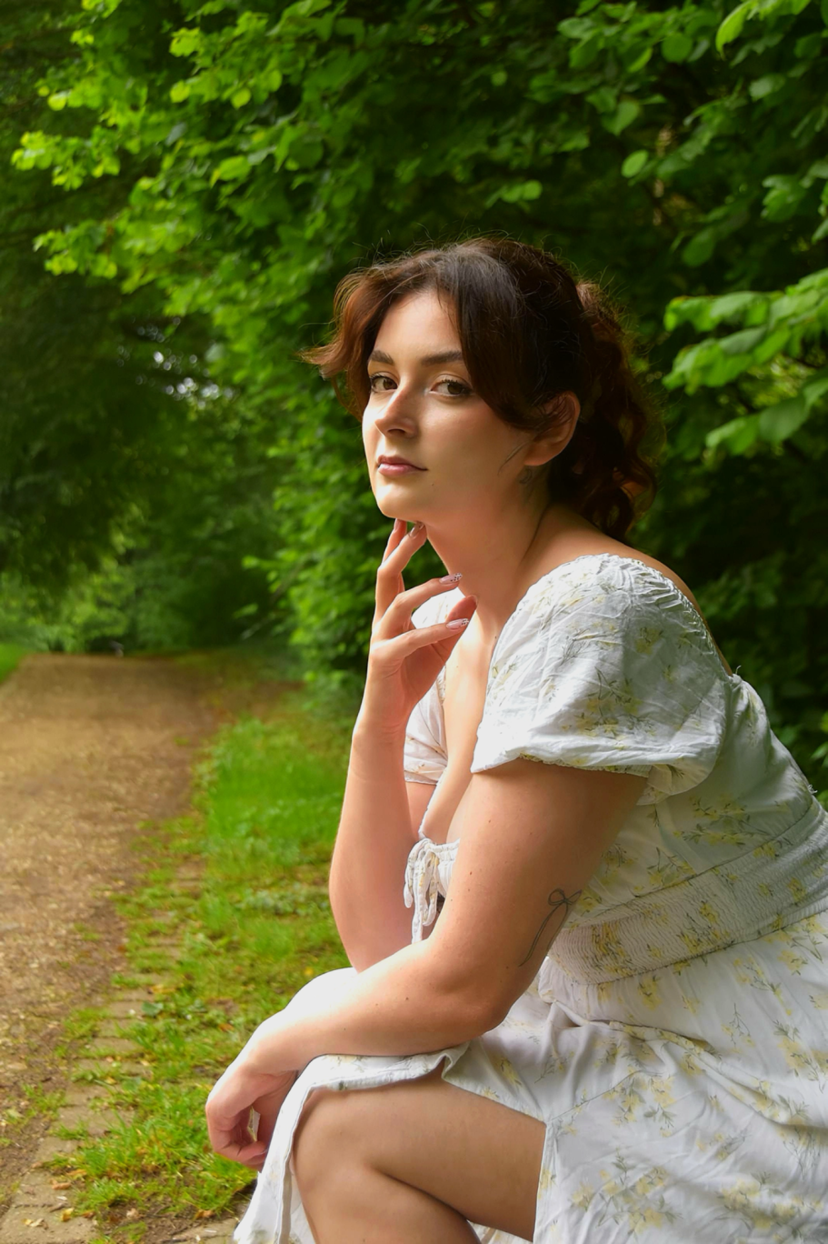 Maddy im hellen Kleid bei einem Portraitshooting im Grünen
